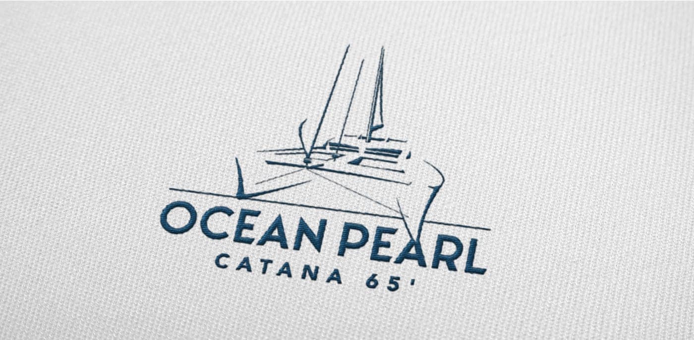 Detall del logotip amb la il·lustració lineal del catamarà brodat en tela clara