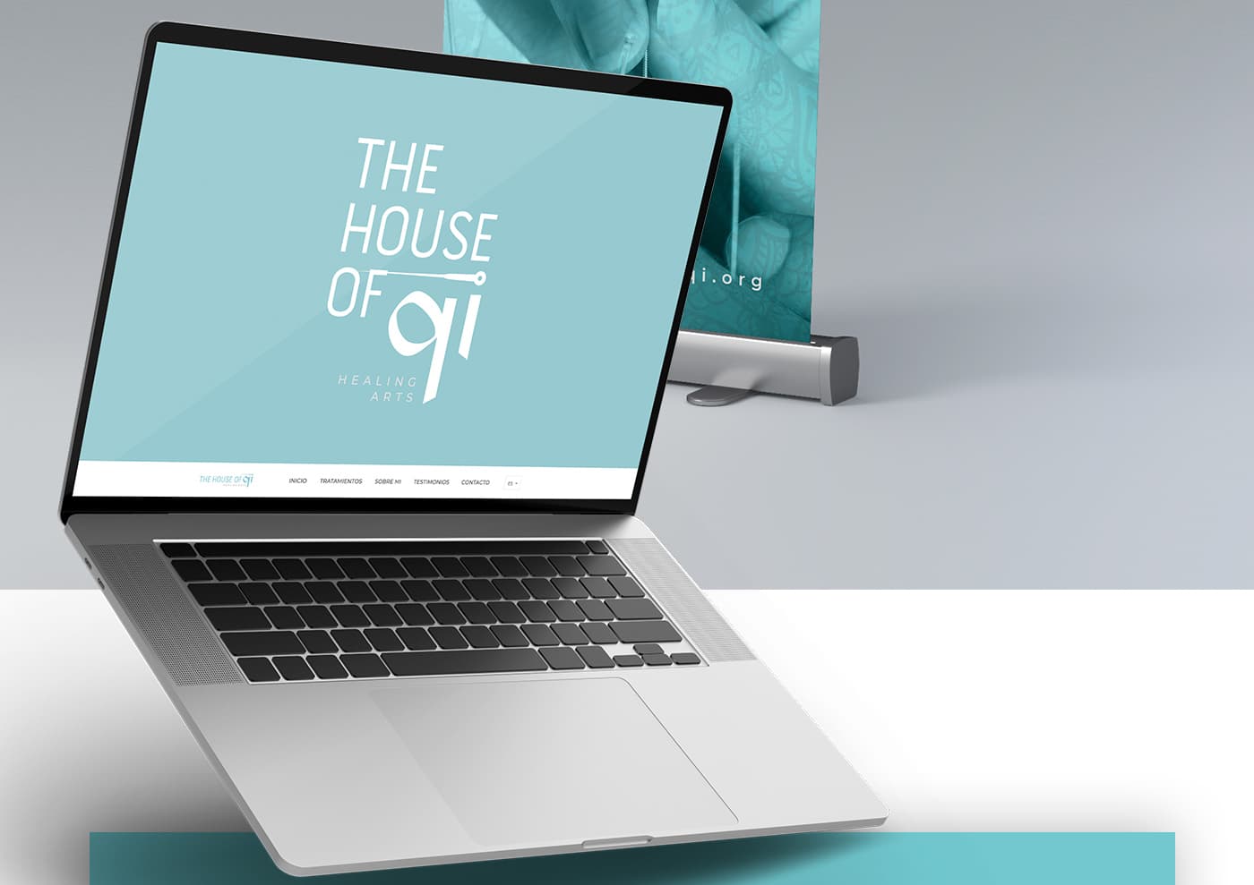 Website mockup on a laptop next to a roll-up with the logotype