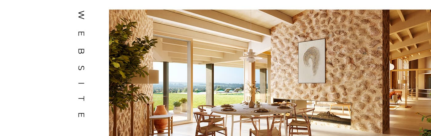 Dining room of one of the homes with a round wooden table next to a marés stone wall