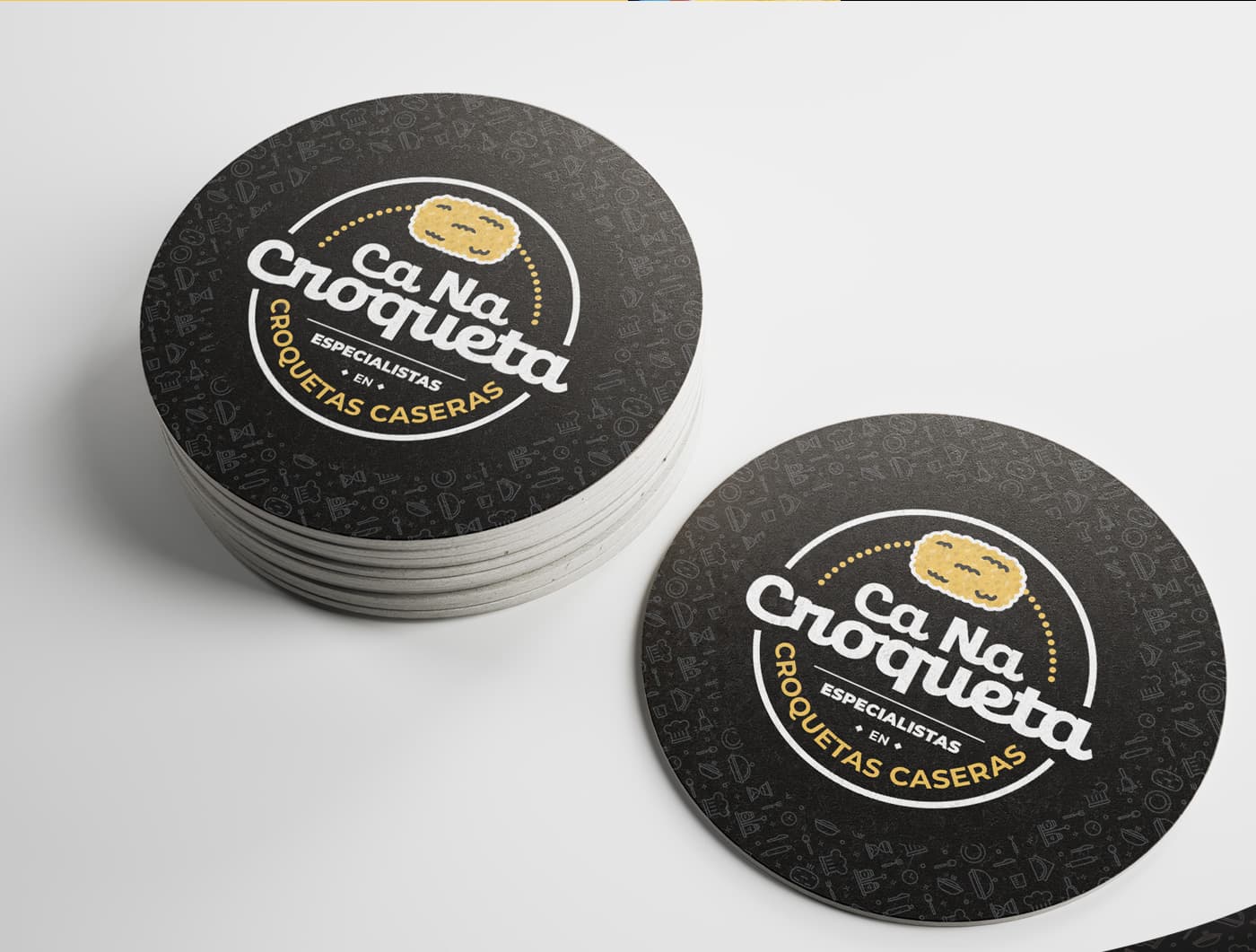 Posavasos rodons en negre amb el logotip de Ca Na Croqueta