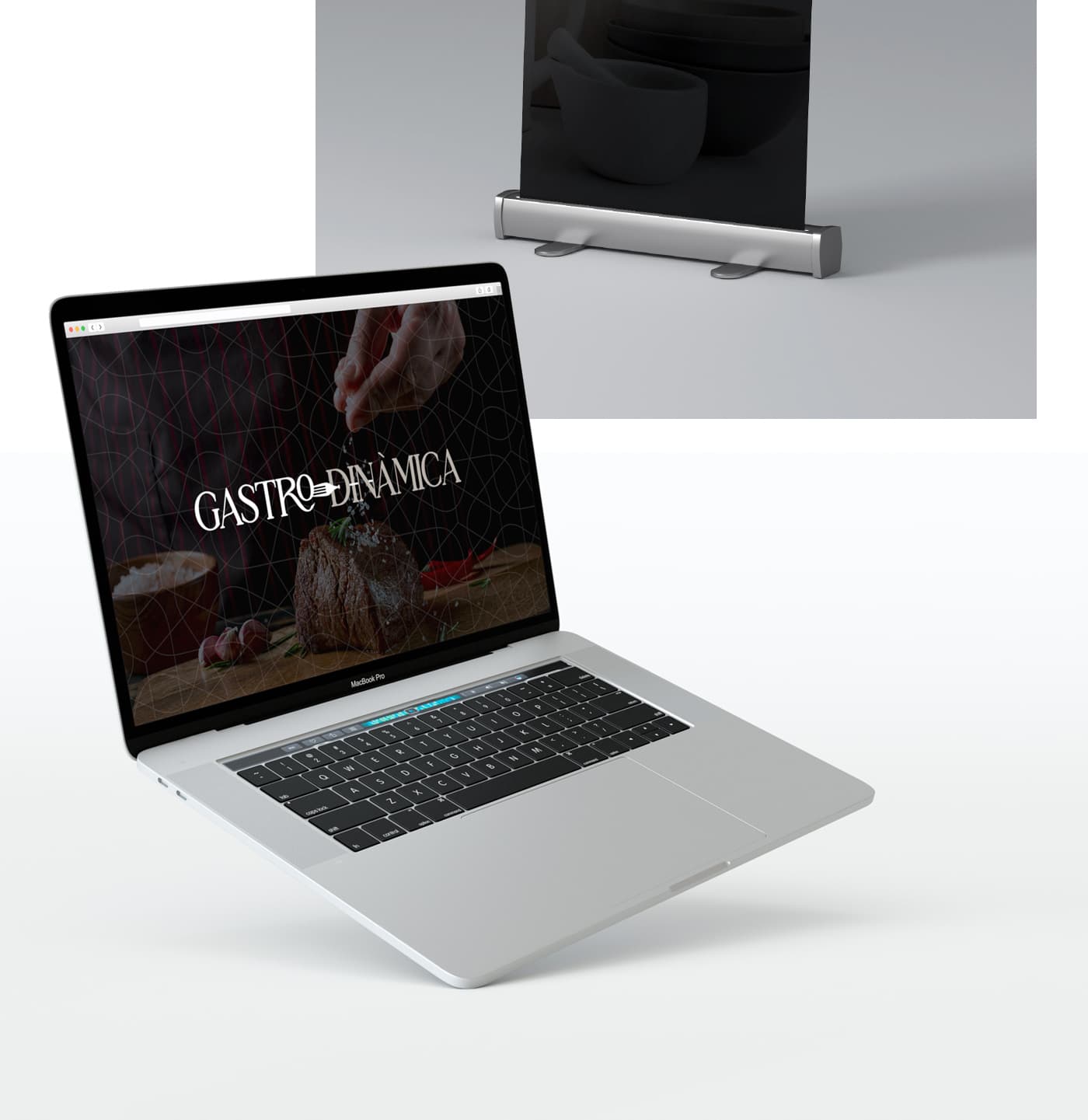 Gastrodinàmica website on a MacBook next to a roll-up with mortar and ceramic bowls