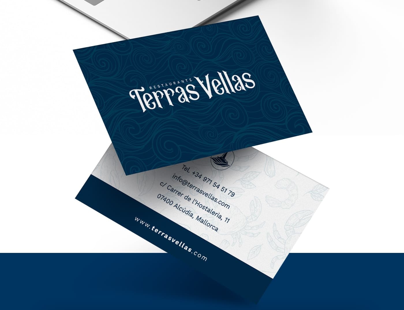 Targetes de visita amb el logotip sobre ones blaves i motius de marisc al revers