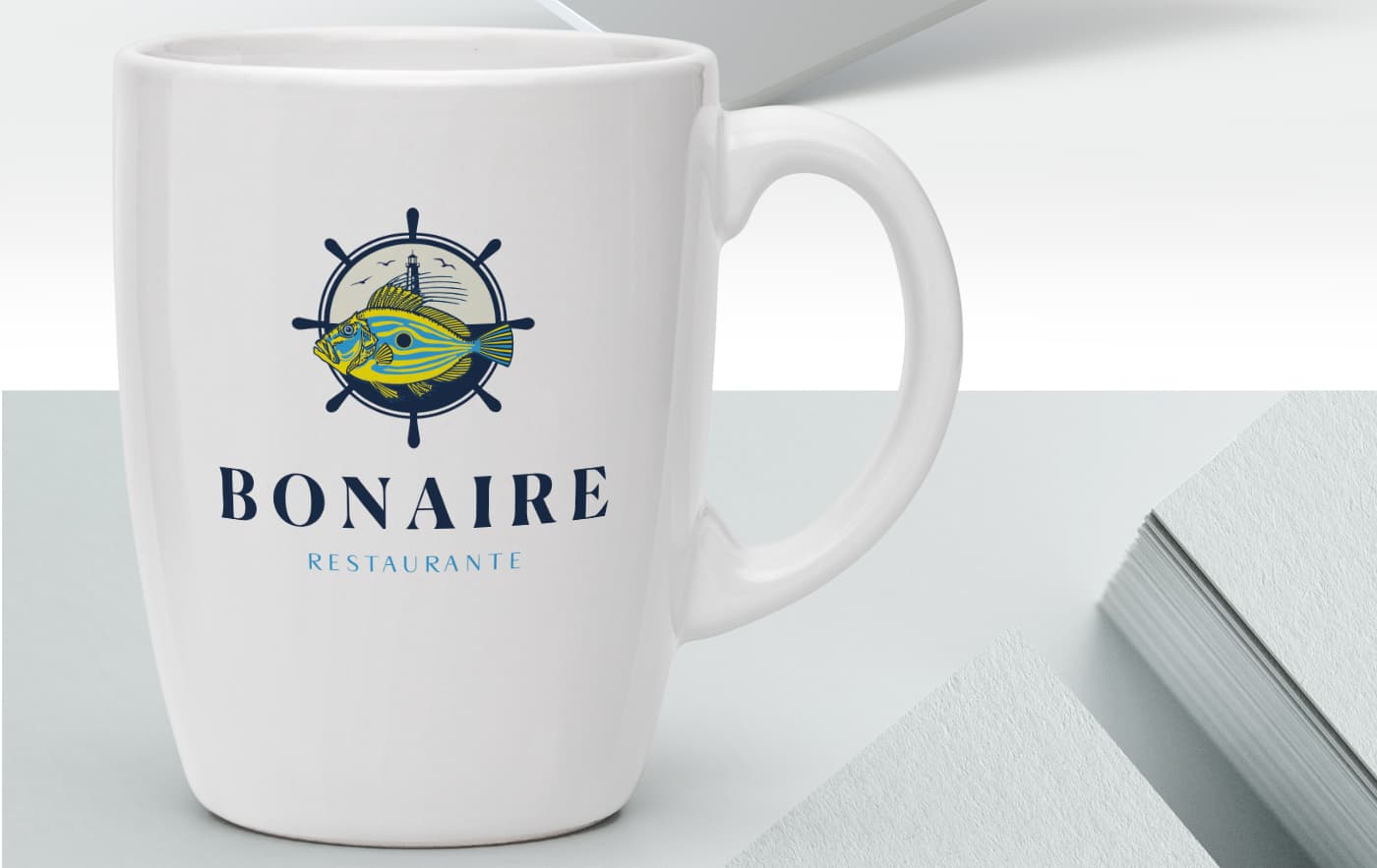 Mockup of a white mug with Bonaire Restaurante's fish and helm logotype