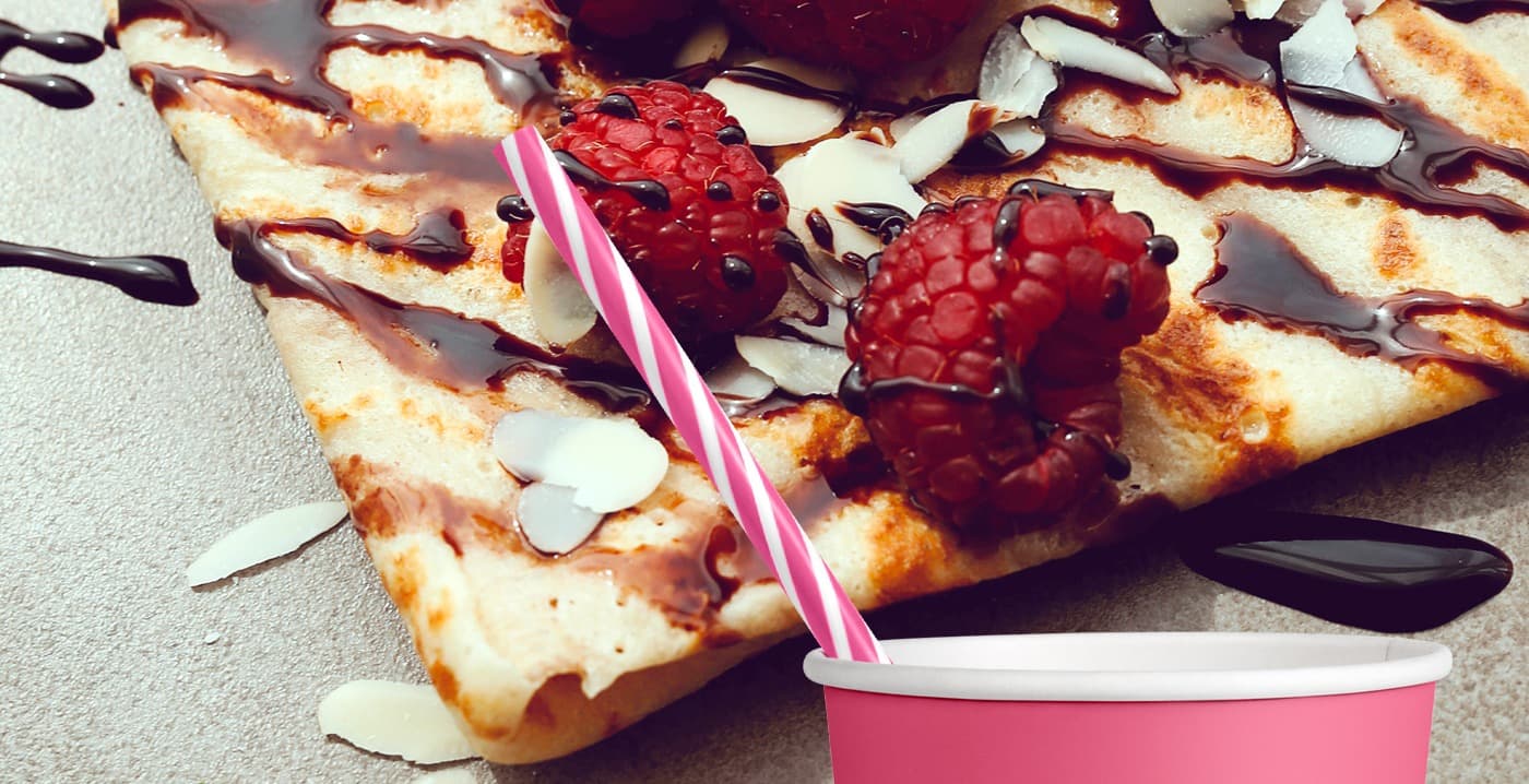 Pajita a rayas rosas sobre un crep con chocolate, frambuesas y almendra laminada
