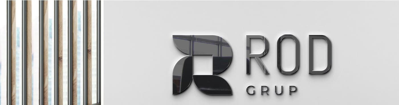 Corporate logo in metallic relief on a wall next to a wooden enclosure
