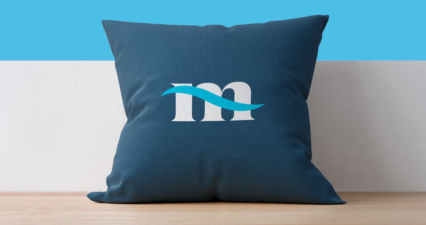 Navy blue decorative cushion with the Mares Properties wave icon