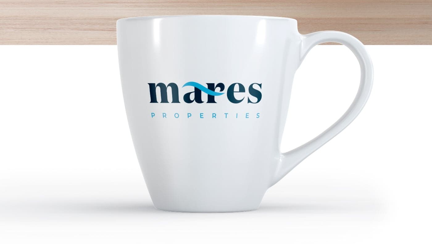 White mug with the Mares Properties logo in navy and sky blue