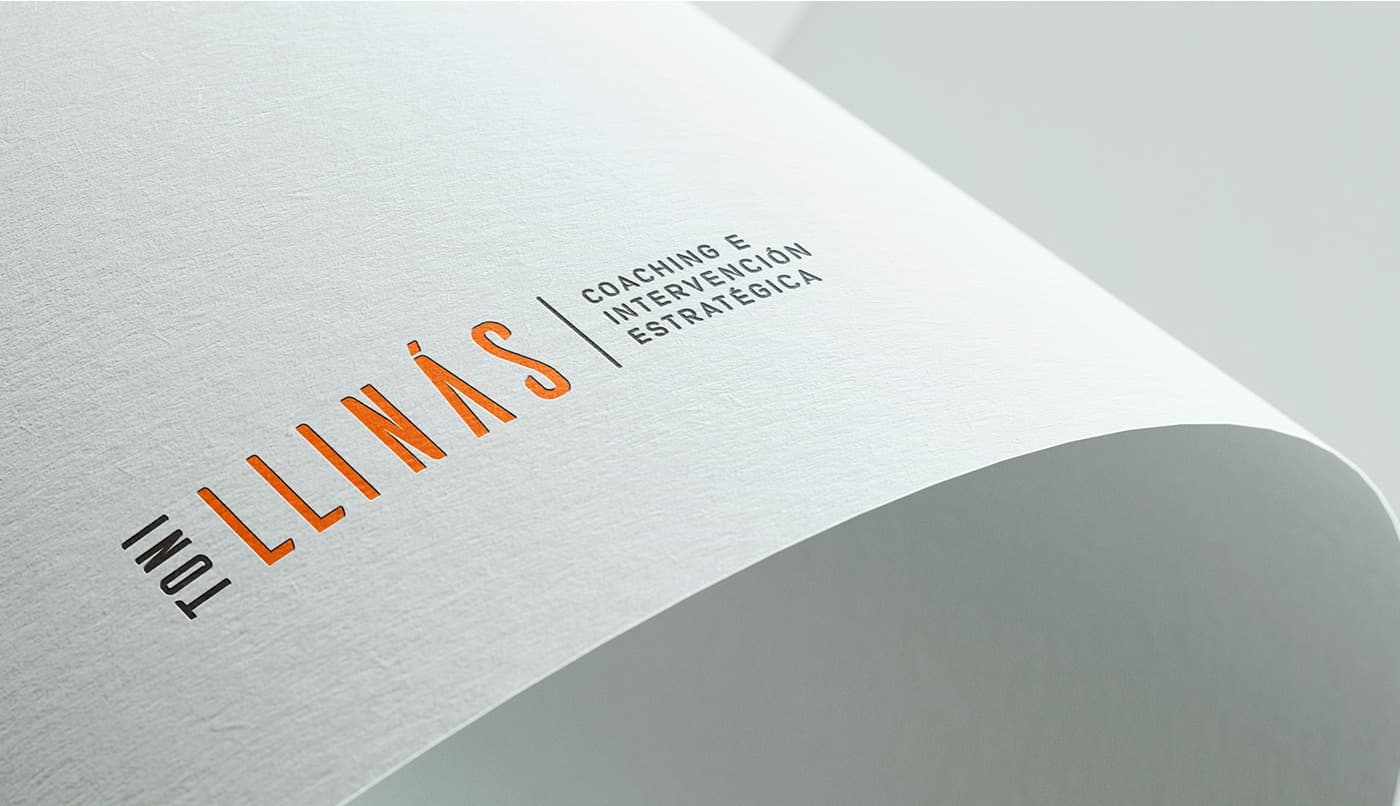 Detalle del logotipo en relieve sobre una hoja de papel curvada