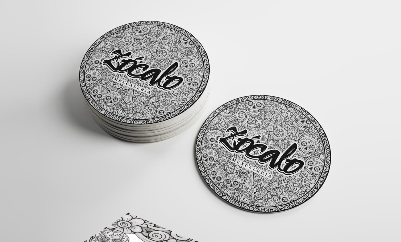 Mockup de posavasos circulares con ilustración de calaveras y el logotipo de Zócalo