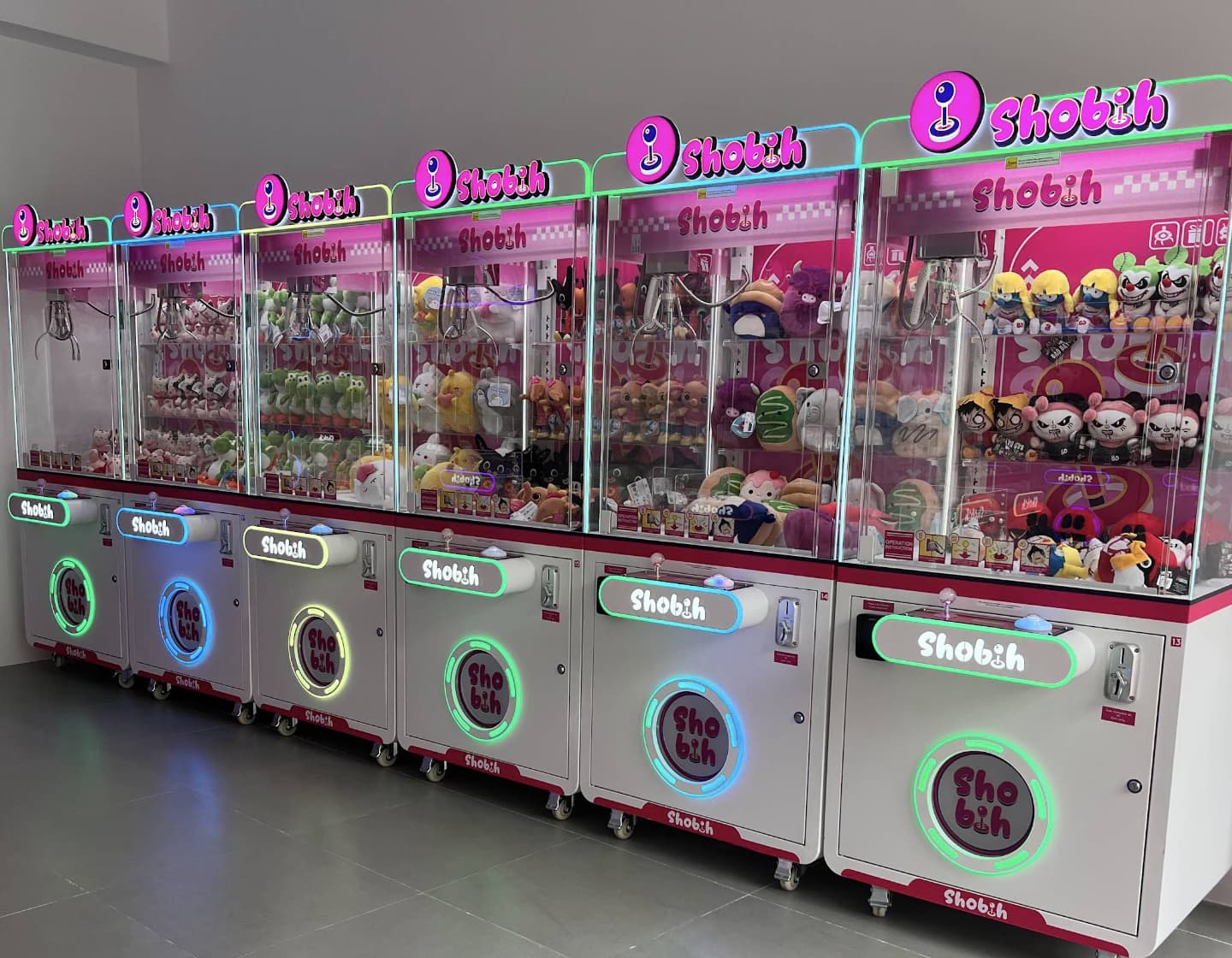 Row of plush claw machines with coloured lights inside the shop